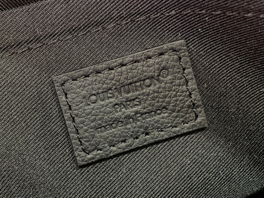 Dark fabric logo label with embossed “LOUIS VUITTON PARIS”