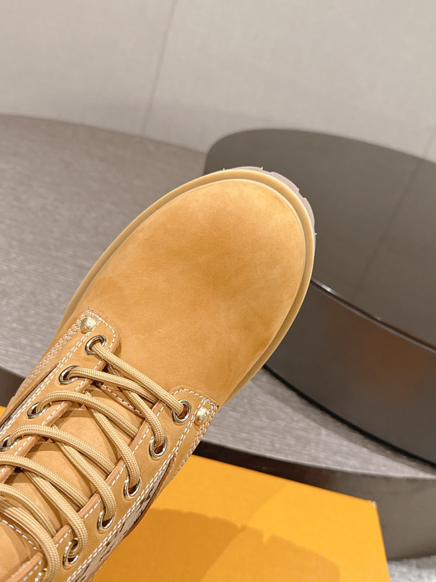 Tan suede lace-up ankle boot with rounded toe and lace-up stitching details