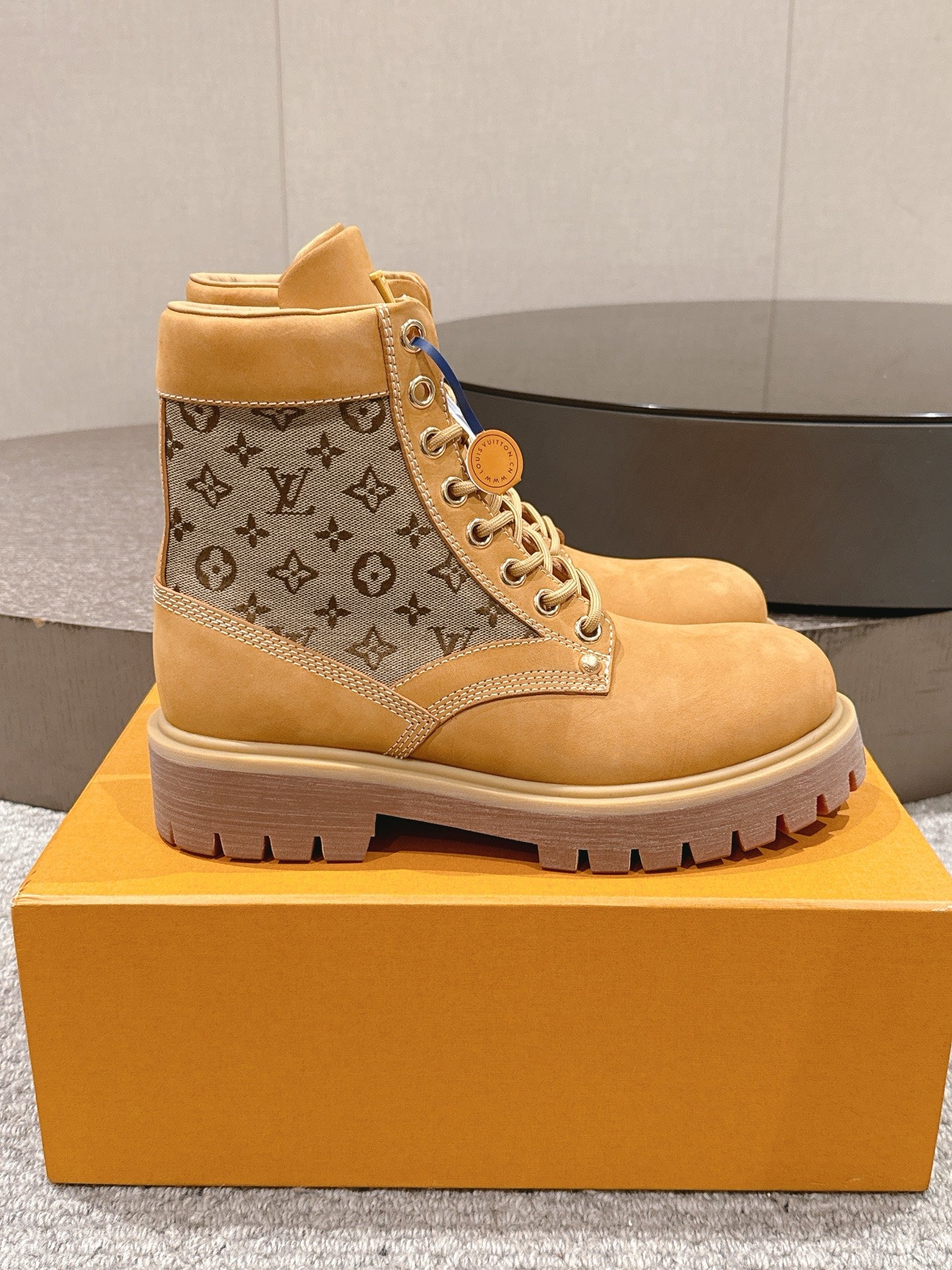 Tan lace-up ankle boots with monogram canvas panels and LV logo, chunky sole