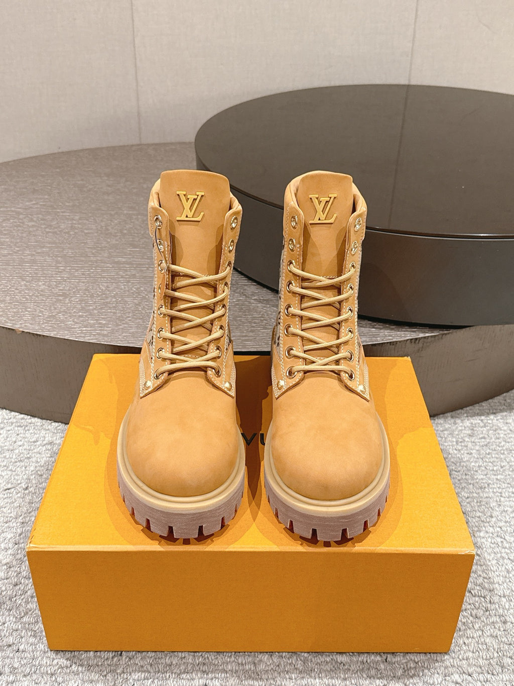 Pair of tan lace-up ankle boots with monogram trim and LV emblem on tongue