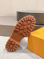 Outsole of tan ankle boots with LV-marked tread and chunky rubber traction