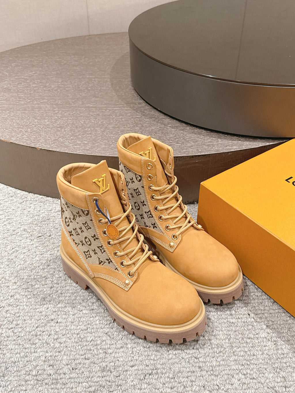 Tan lace-up ankle boots with monogram side panels and padded high collar