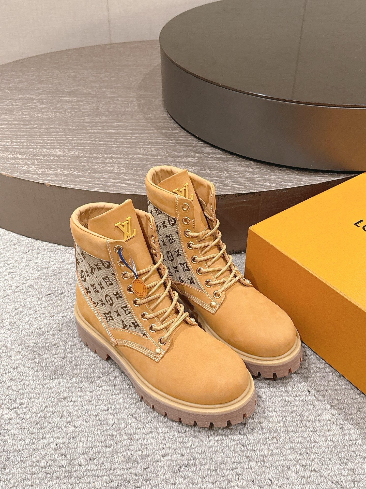 Tan lace-up ankle boots with monogram side panels and padded high collar