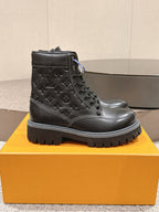 Black lace-up leather boots with embossed monogram pattern and thick rubber sole