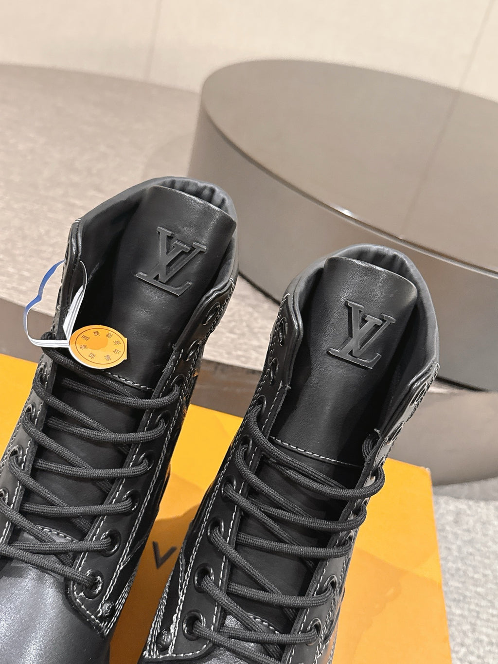 Black high-top lace-up boots with LV logo on tongue, grippy rubber sole