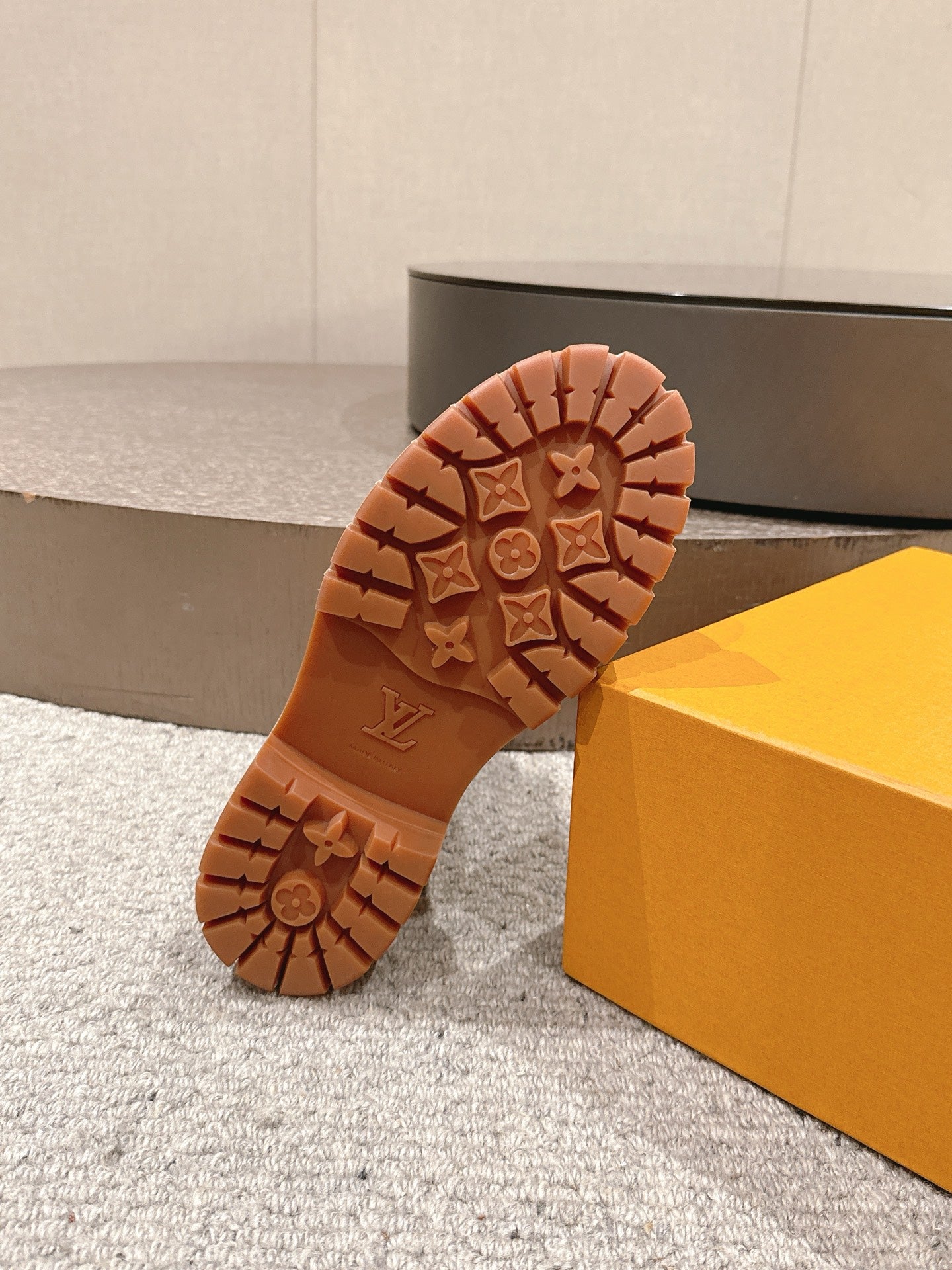 Bottom view of tan boot outsole with LV monogram tread and lug pattern