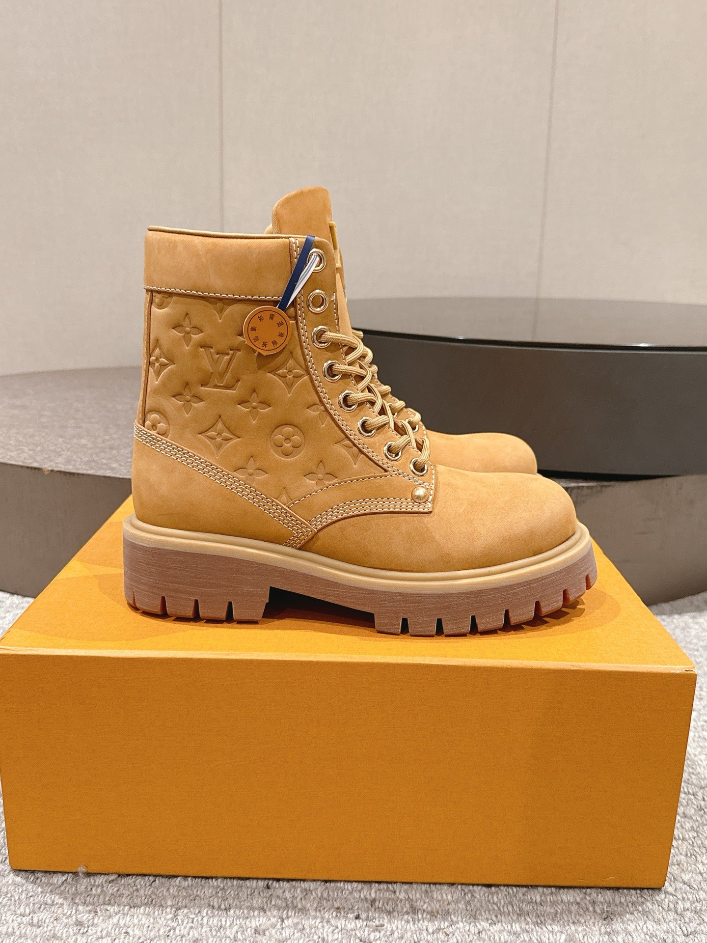 Tan suede ankle boot with lace-up front and LV monogram on side
