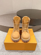 Pair of tan lace-up ankle boots with LV logo on tongue and treaded rubber sole