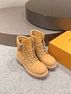 Tan suede lace-up ankle boots, angled view, with LV logo patches and chunky sole