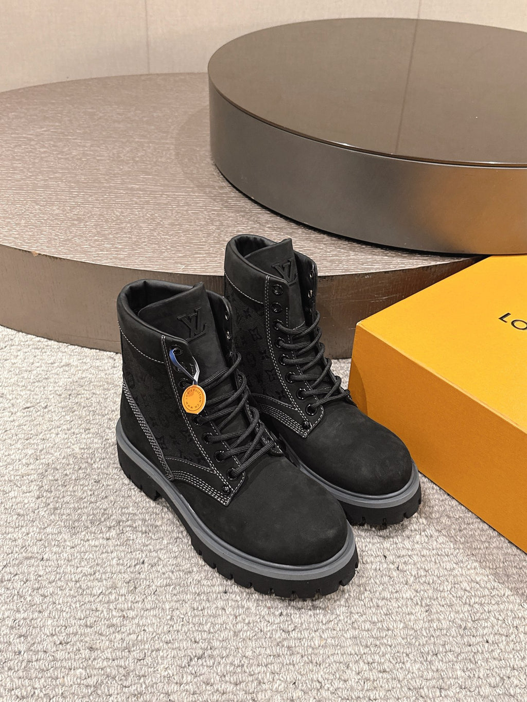 Black lace-up ankle boots with side logo patch and thick rubber sole