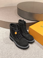 Black lace-up ankle boots with side logo patch and thick rubber sole