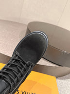 Black suede lace-up ankle boot close-up with stitched detail on toe area