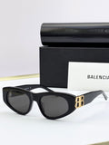 Black cat-eye sunglasses with dark lenses and gold B logo on temples