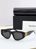 Black cat-eye sunglasses with dark lenses and gold B logo on temples