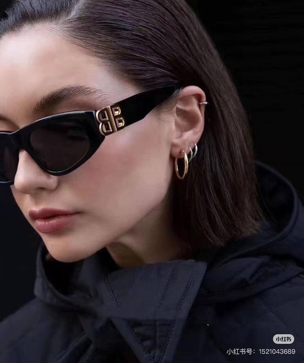 Black cat-eye sunglasses with dark lenses and gold B logo on the temple