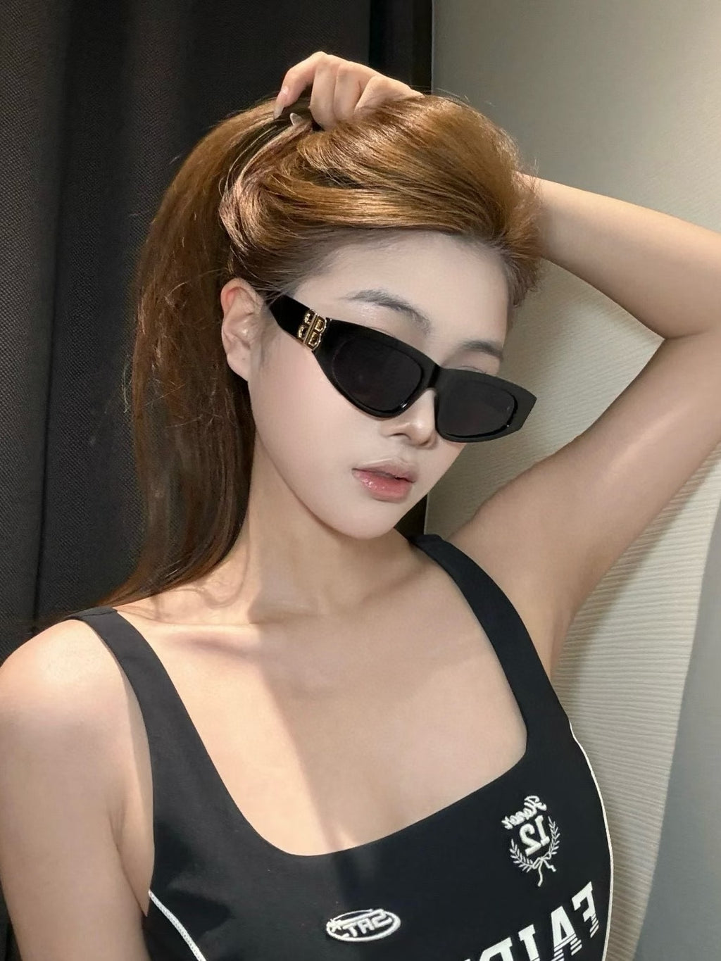 Black sunglasses with dark lenses and gold B logo at the temple hinge