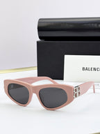 Blush pink cat-eye sunglasses with dark lenses and gold B logo on temples