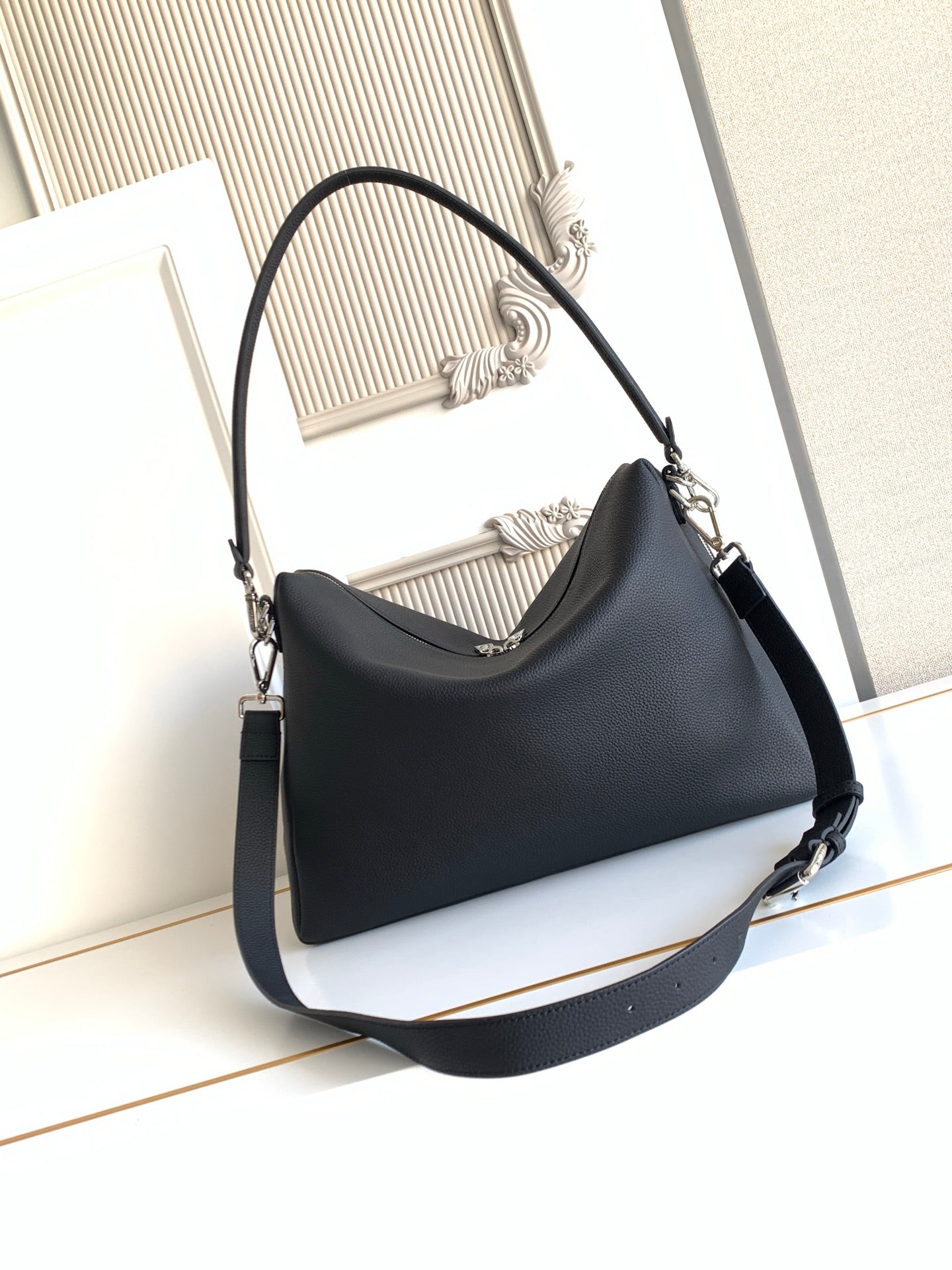 Dark leather shoulder bag with thick strap and front panel stitching