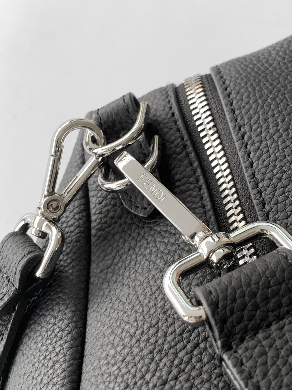 Black leather bag with silver lobster clasps and zipper pull hardware
