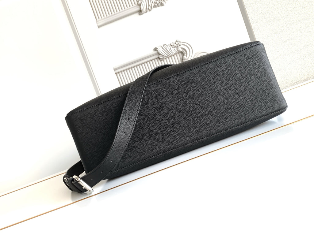 Black leather clutch-style bag with top zipper and long shoulder strap
