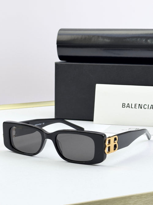 Balenciaga sunglasses with black frames and gold B logo temples, dark lenses