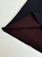 Black long-sleeve top showing dark red knit interior hem panel