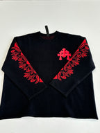 Black long-sleeve top with red cross and floral-style chest graphic