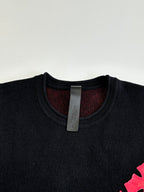 Black long-sleeve top with ribbed crew neck and visible size tag