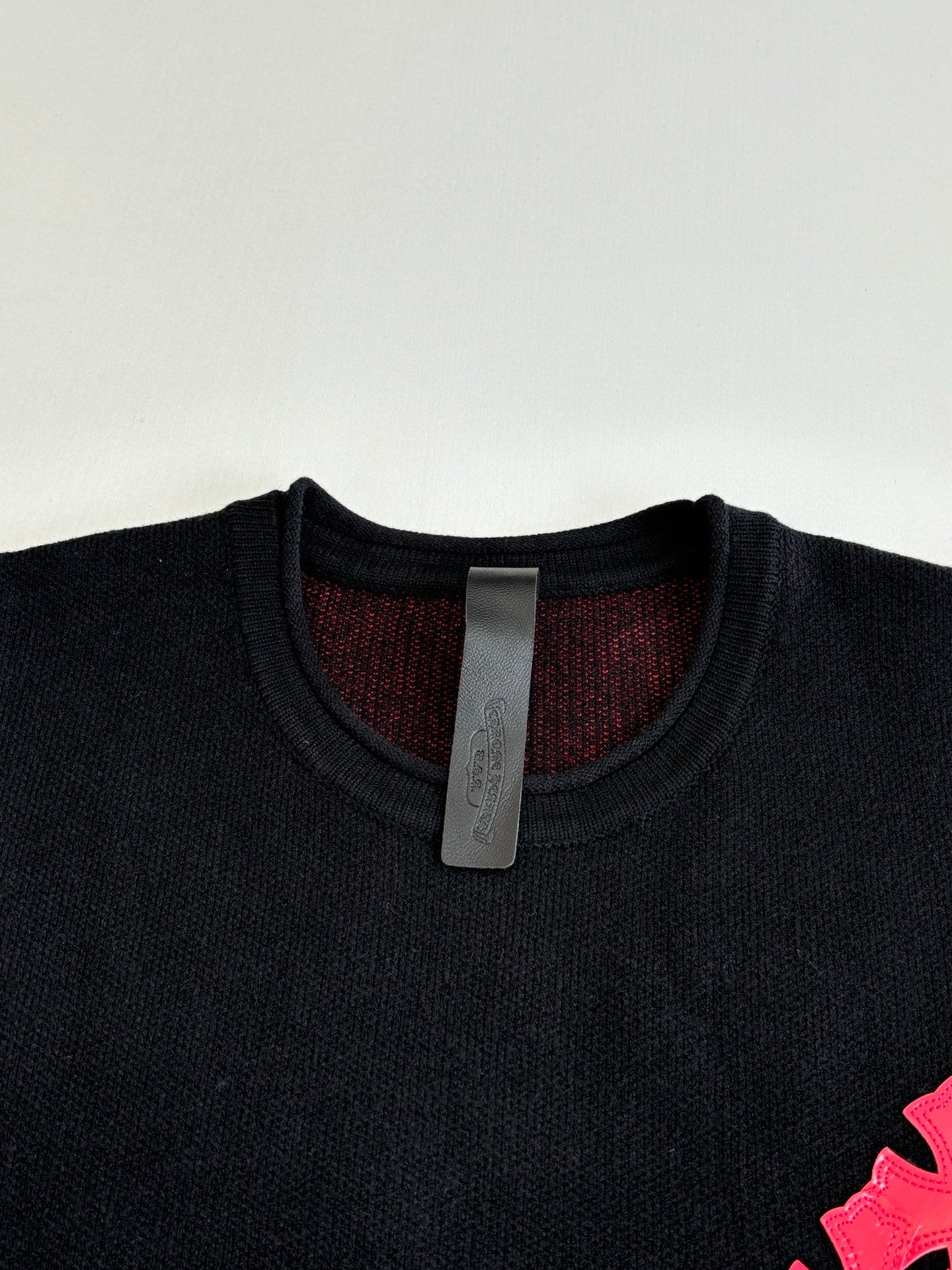 Black long-sleeve top with ribbed crew neck and visible size tag