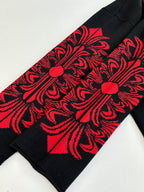 Black long-sleeve top with red ornate sleeve panel graphic