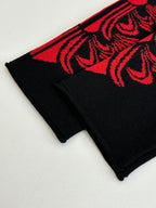 Black long-sleeve top with red ornate cuff stripe detail