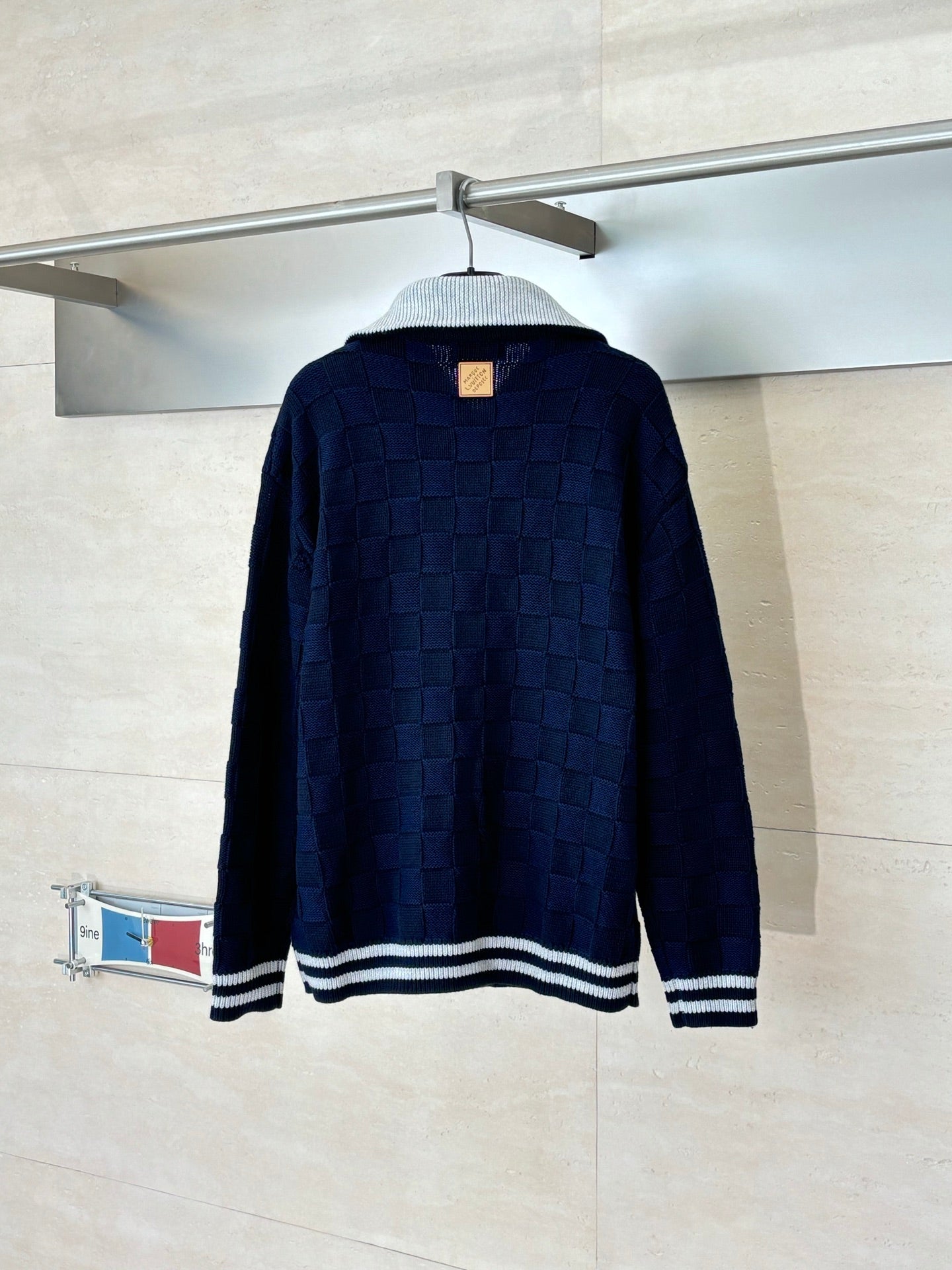 Louis Vuitton navy knit zip jacket, back view with striped hem and gold zipper pull