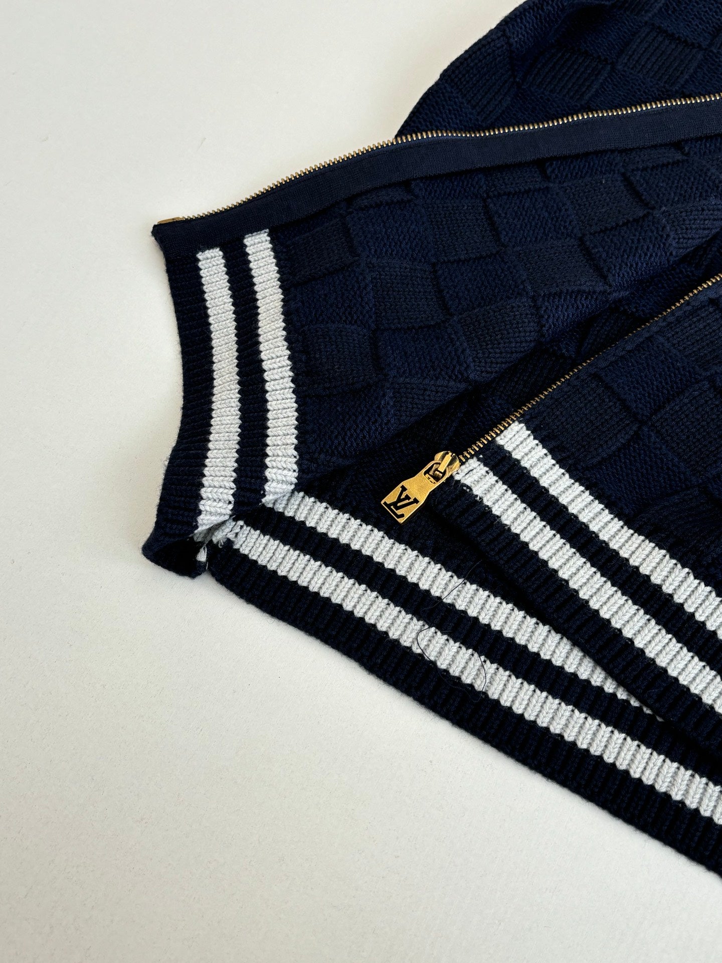 Louis Vuitton navy knit sleeve with striped trim and gold zipper detail