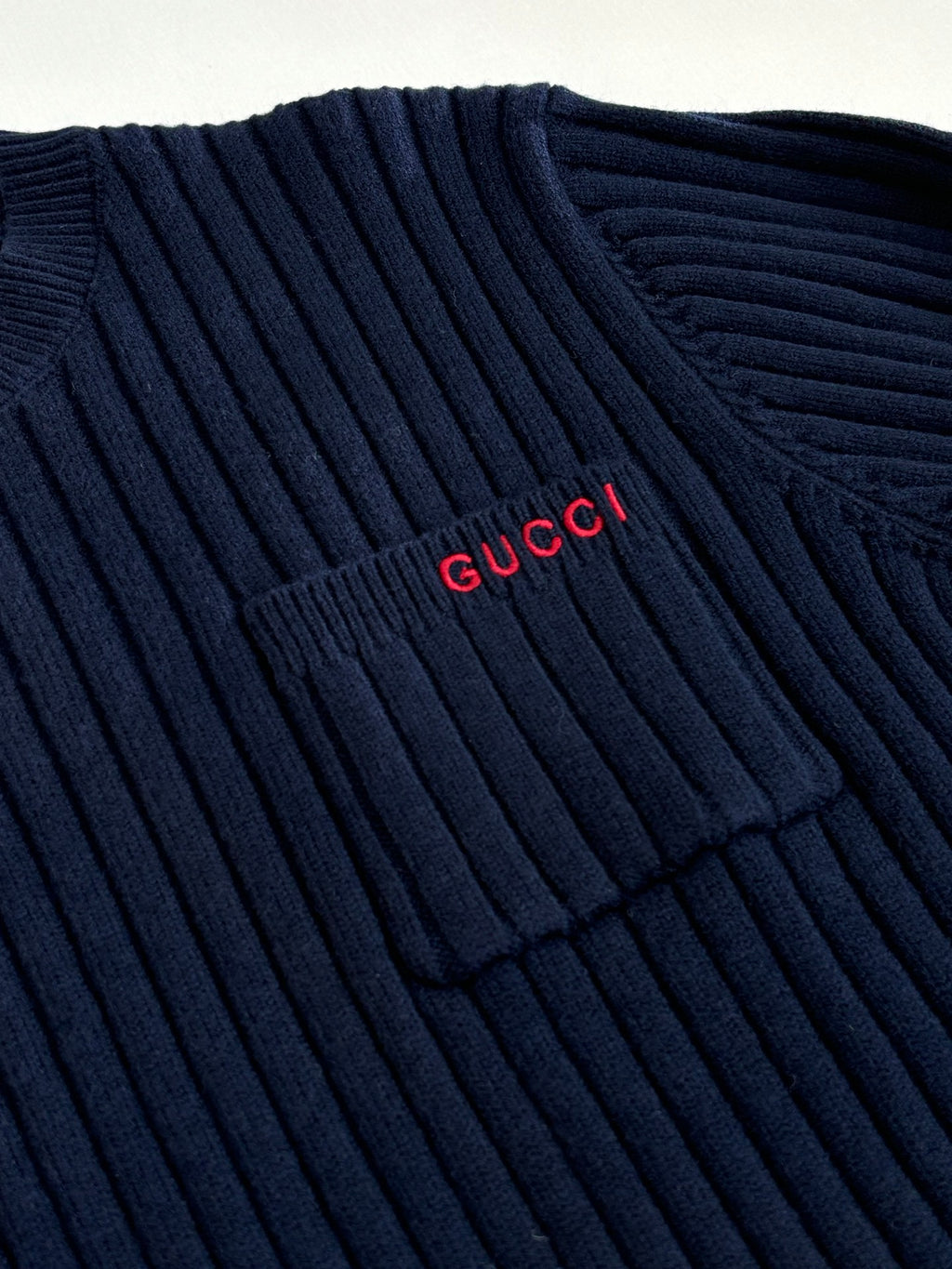 Navy knit sweater with red Gucci logo near shoulder