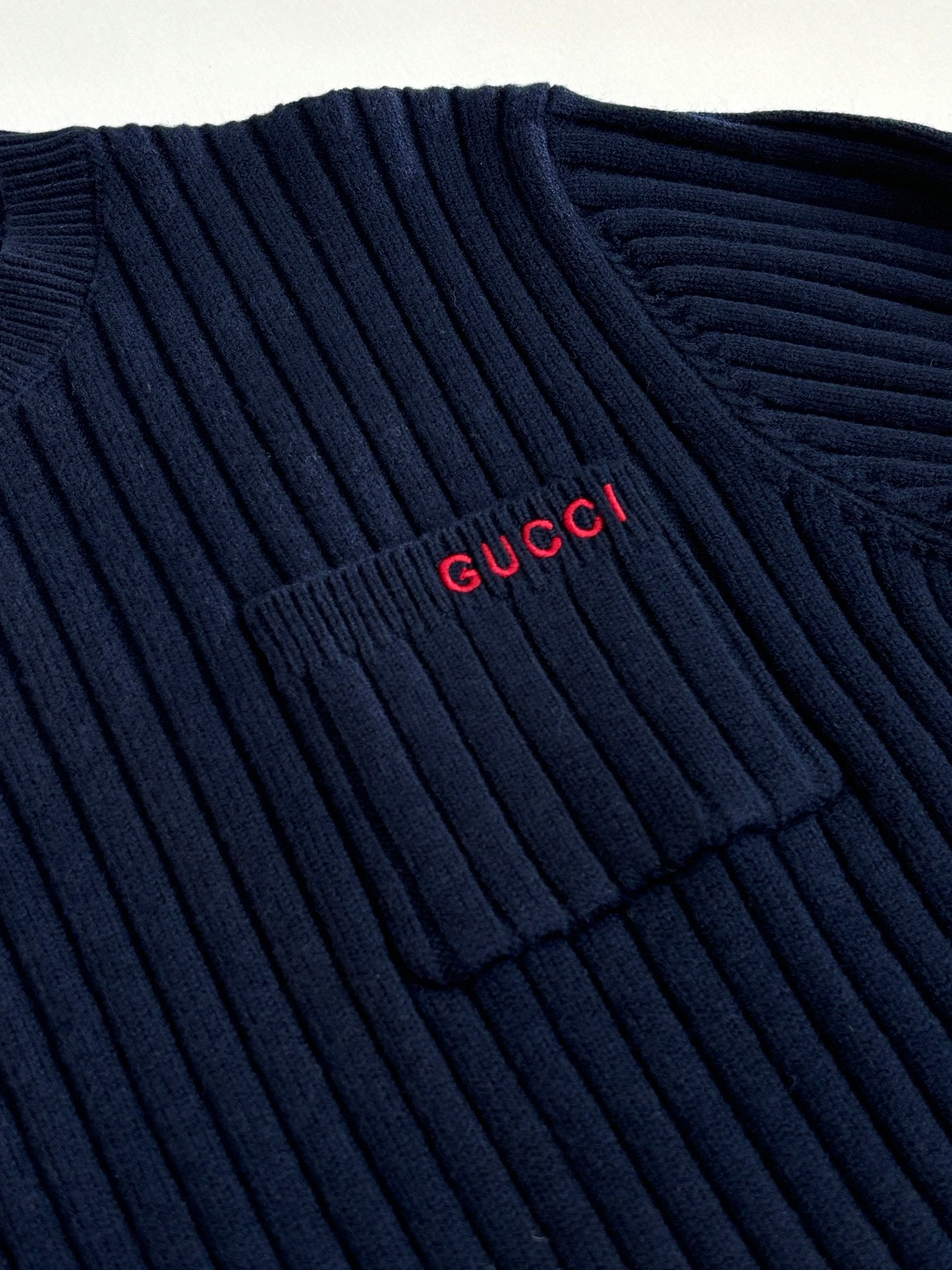 Navy knit sweater with red Gucci logo near shoulder