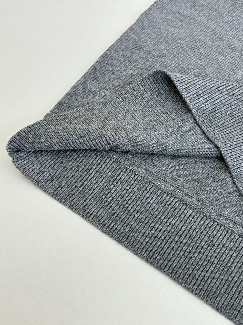 Grey knit sweater ribbed cuff and side seam detail