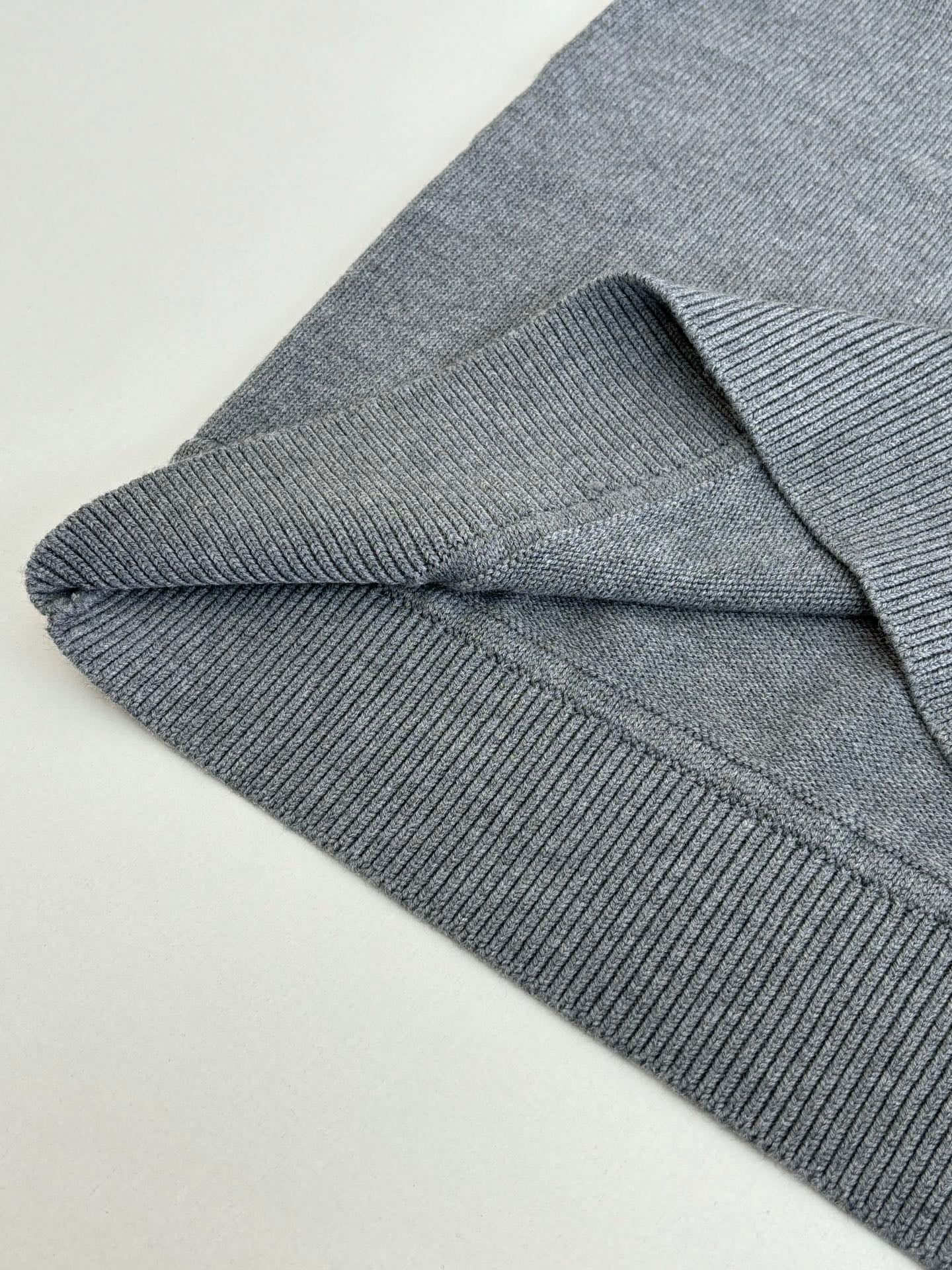 Grey knit sweater ribbed cuff and side seam detail