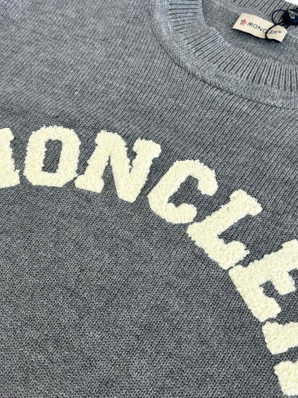 Grey knit sweater showing MONCLER lettering detail