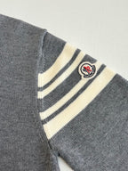 Grey sweater sleeve with striped armband and Moncler logo patch