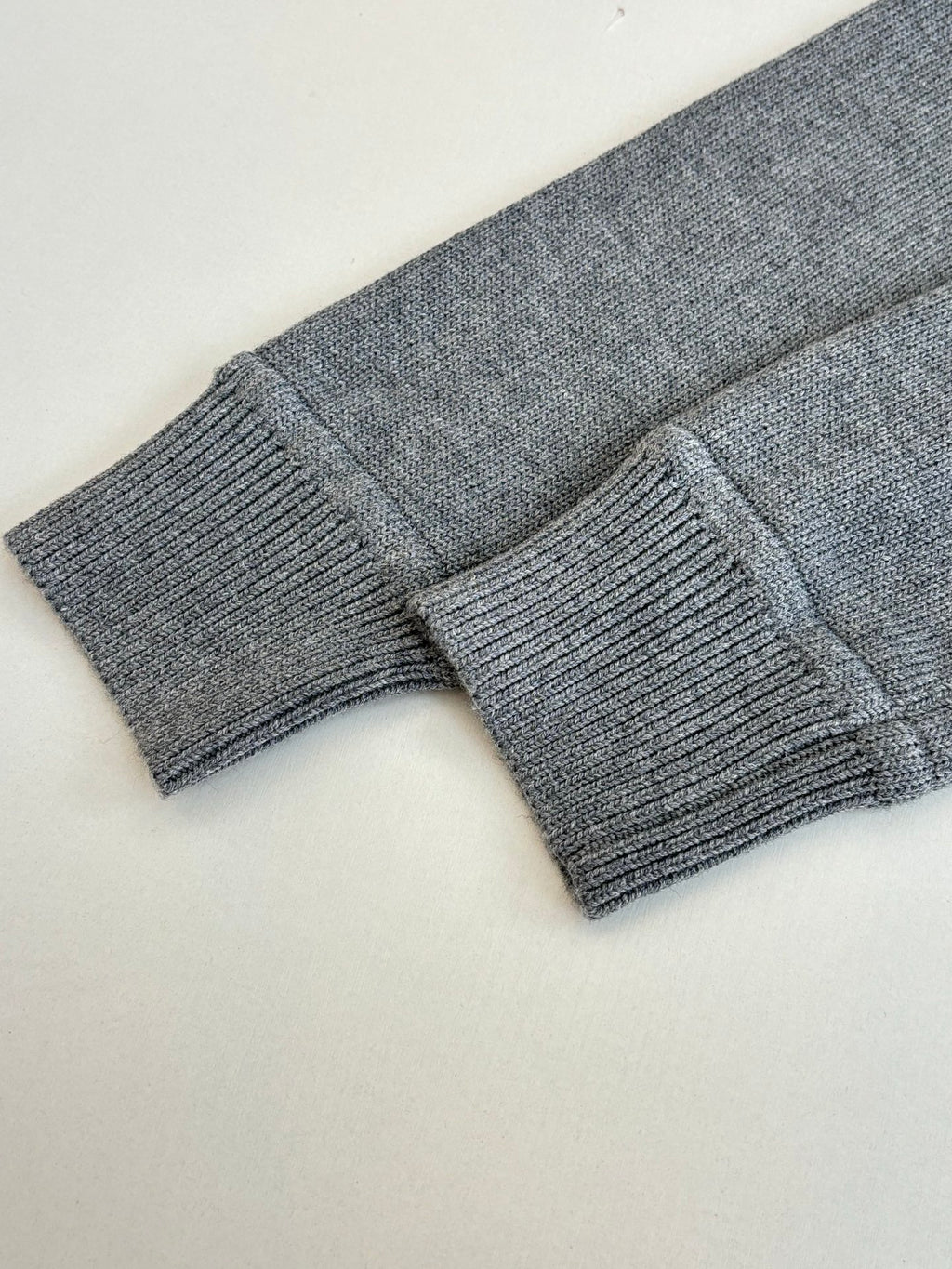 Grey knit sweater sleeve cuffs and ribbed hem detail