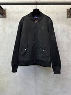 Black zip-up bomber jacket with stand collar, full front zipper, and flap pockets.