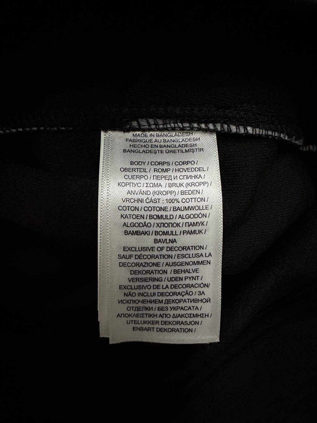 Interior care label on black fabric with white printed text.