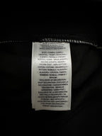 Interior care label on black fabric with white printed text.