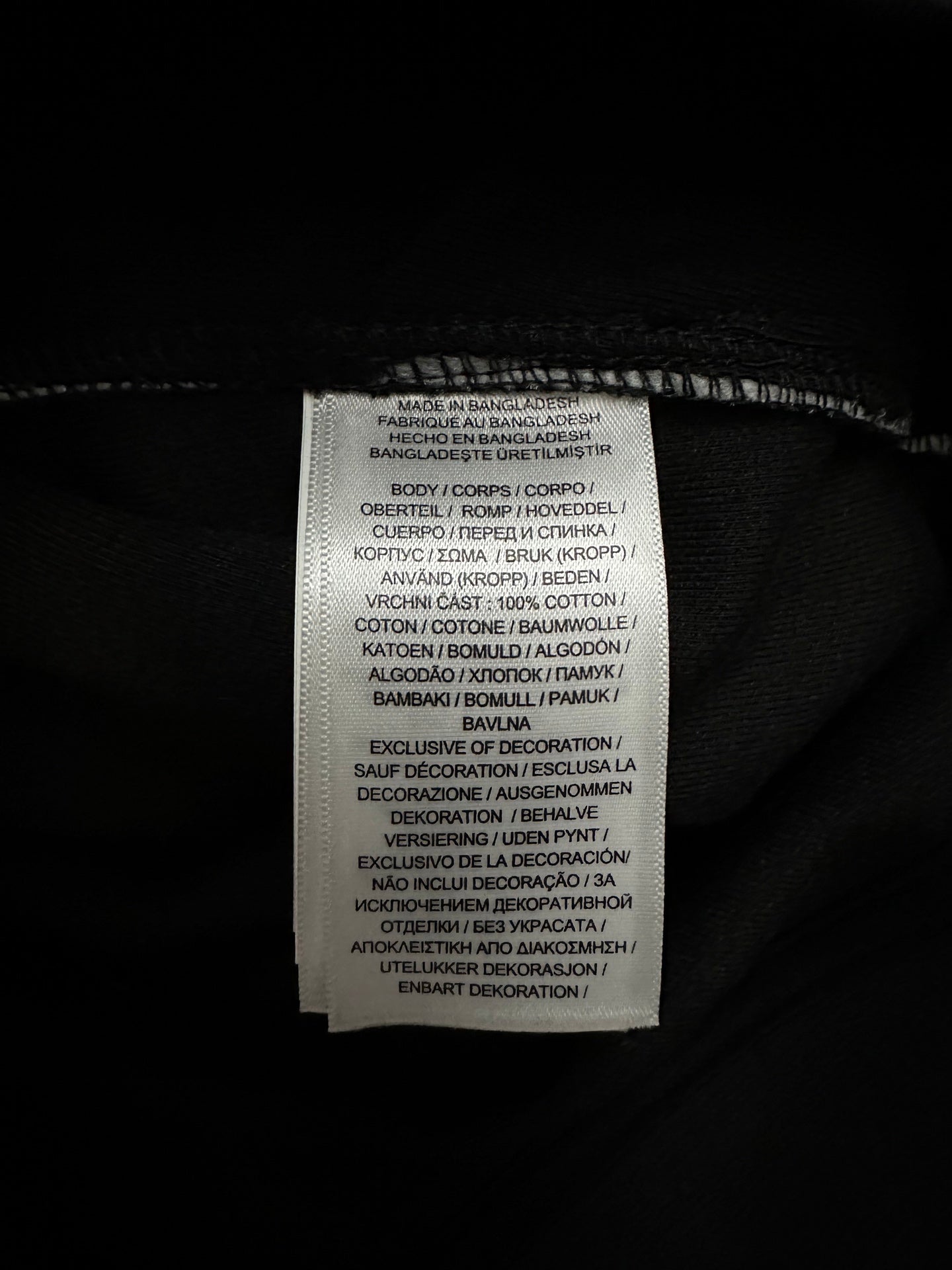 Interior care label on black fabric with white printed text.