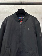 Black zip-up bomber jacket with chest logo embroidery and full front zipper.