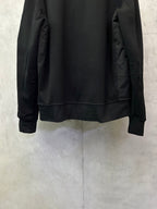 Black zip-up jacket back with ribbed waistband and full-length sleeves.