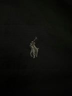 Embroidered polo rider logo on black fabric.