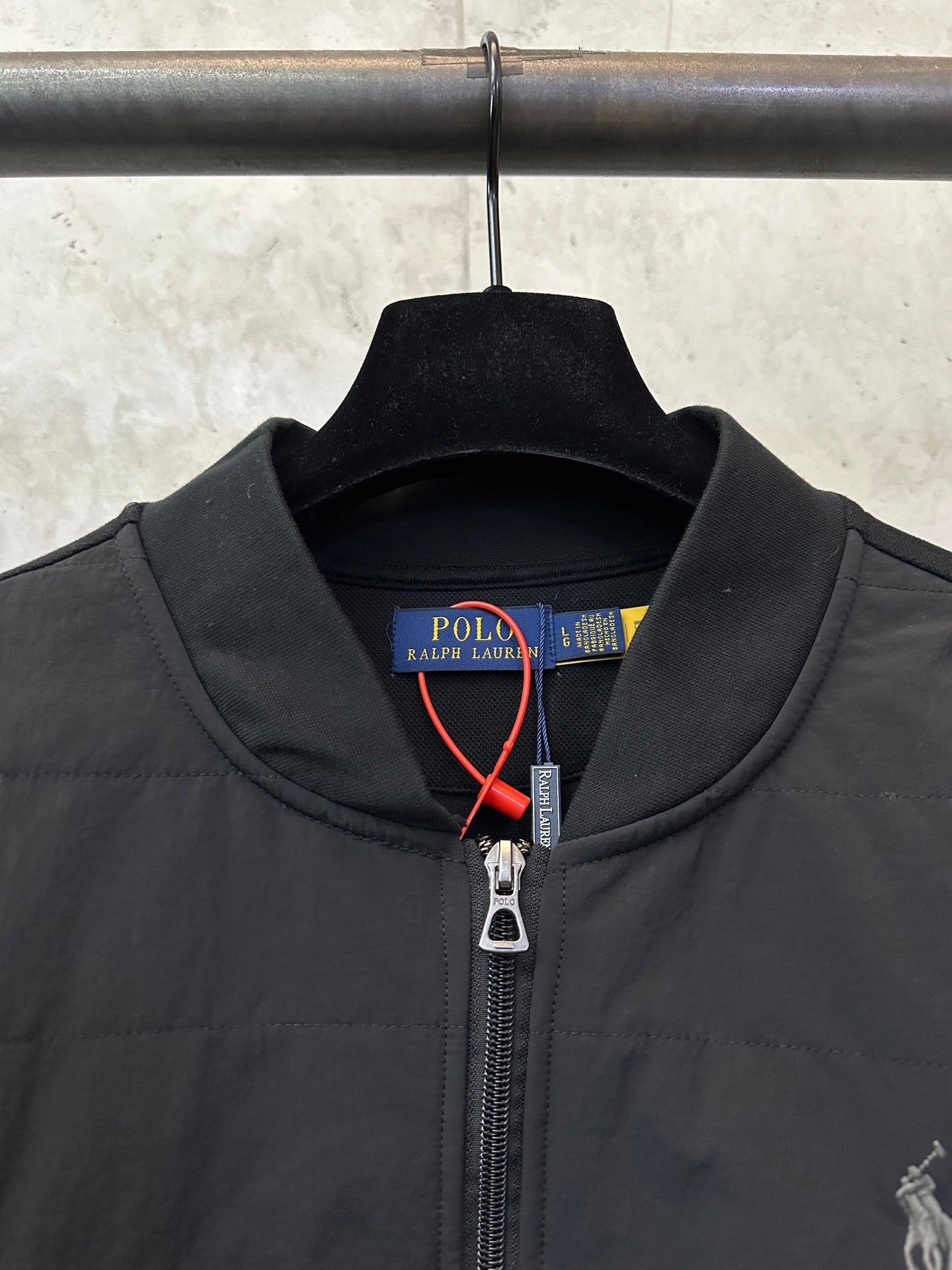 Black jacket collar with Polo Ralph Lauren label and metal zipper pull.