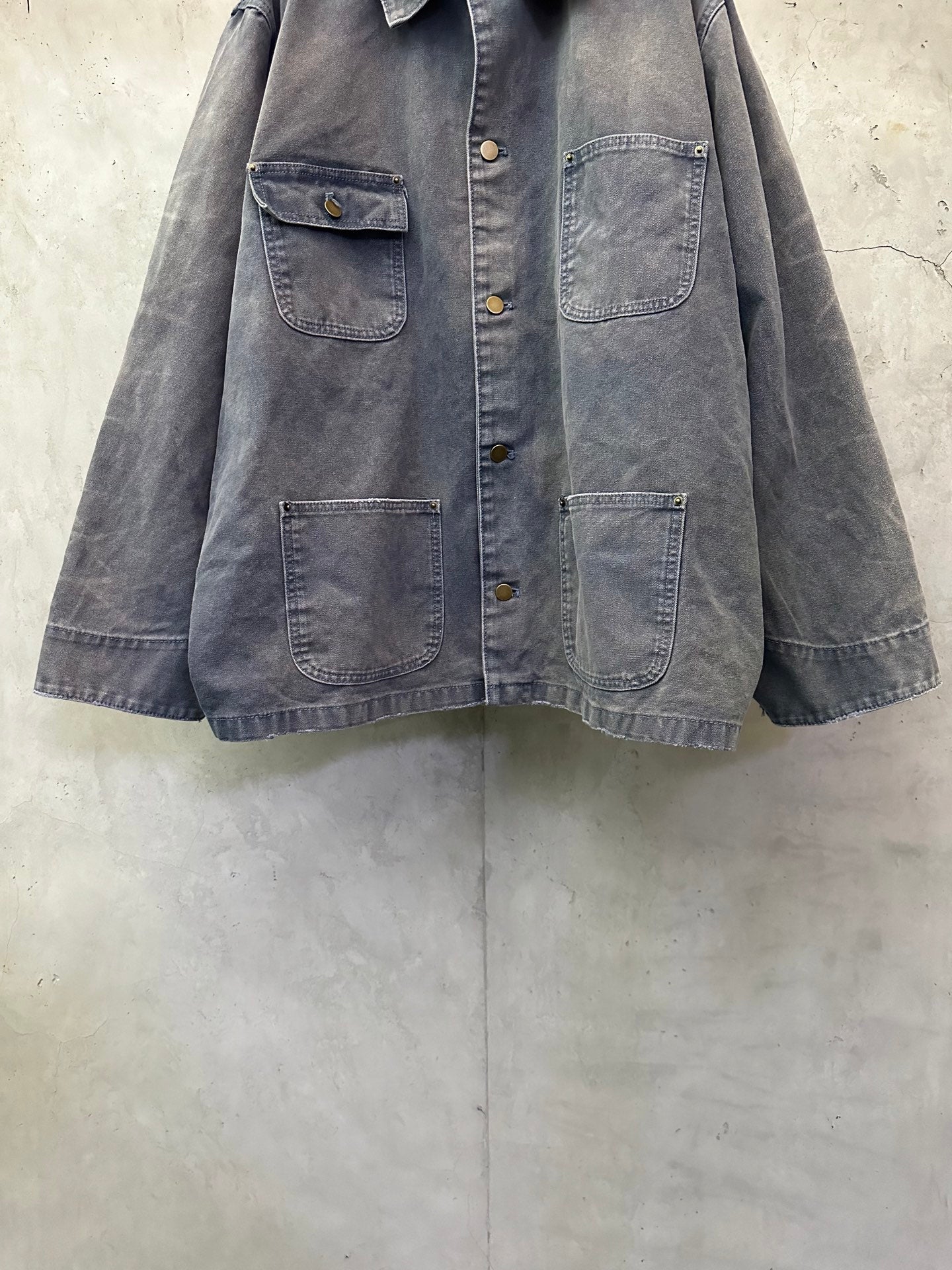 Long denim jacket with four flap pockets and dark blue-gray wash, button front