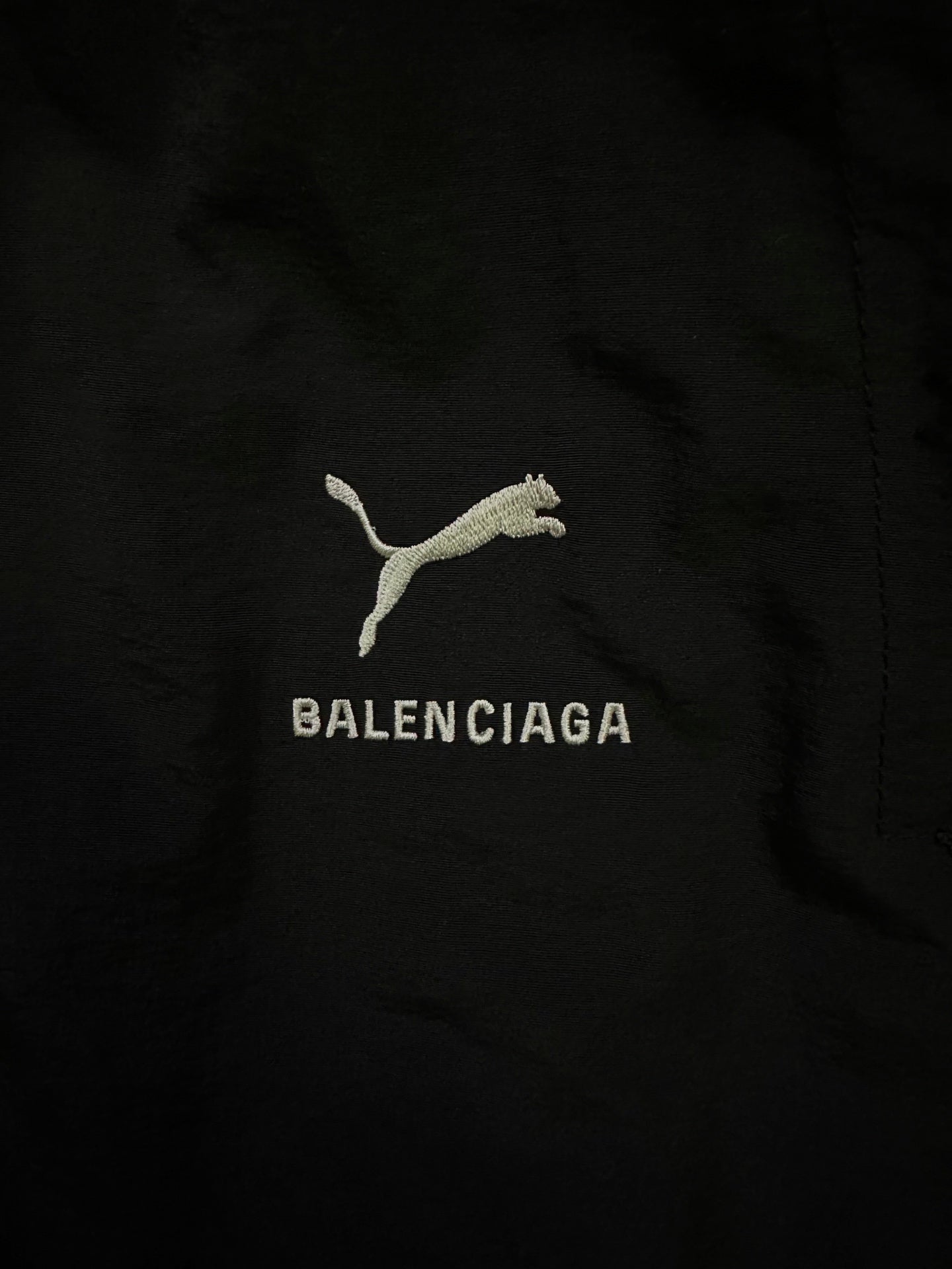 Balenciaga logo embroidery on black pants with cat icon and text